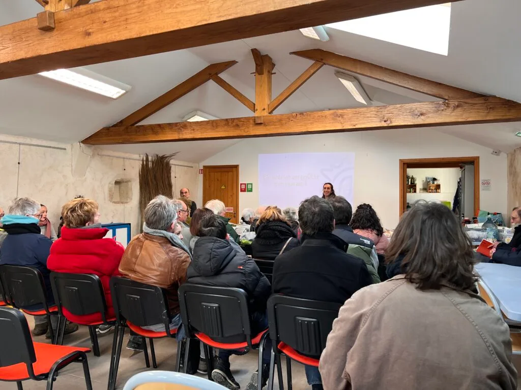 Des participants rassemblés autour d’un goûter champêtre, partageant crêpes et échanges sur la préservation des zones humides.