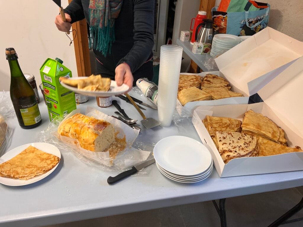 es participants rassemblés autour d’un goûter champêtre, partageant crêpes et échanges sur la préservation des zones humides.